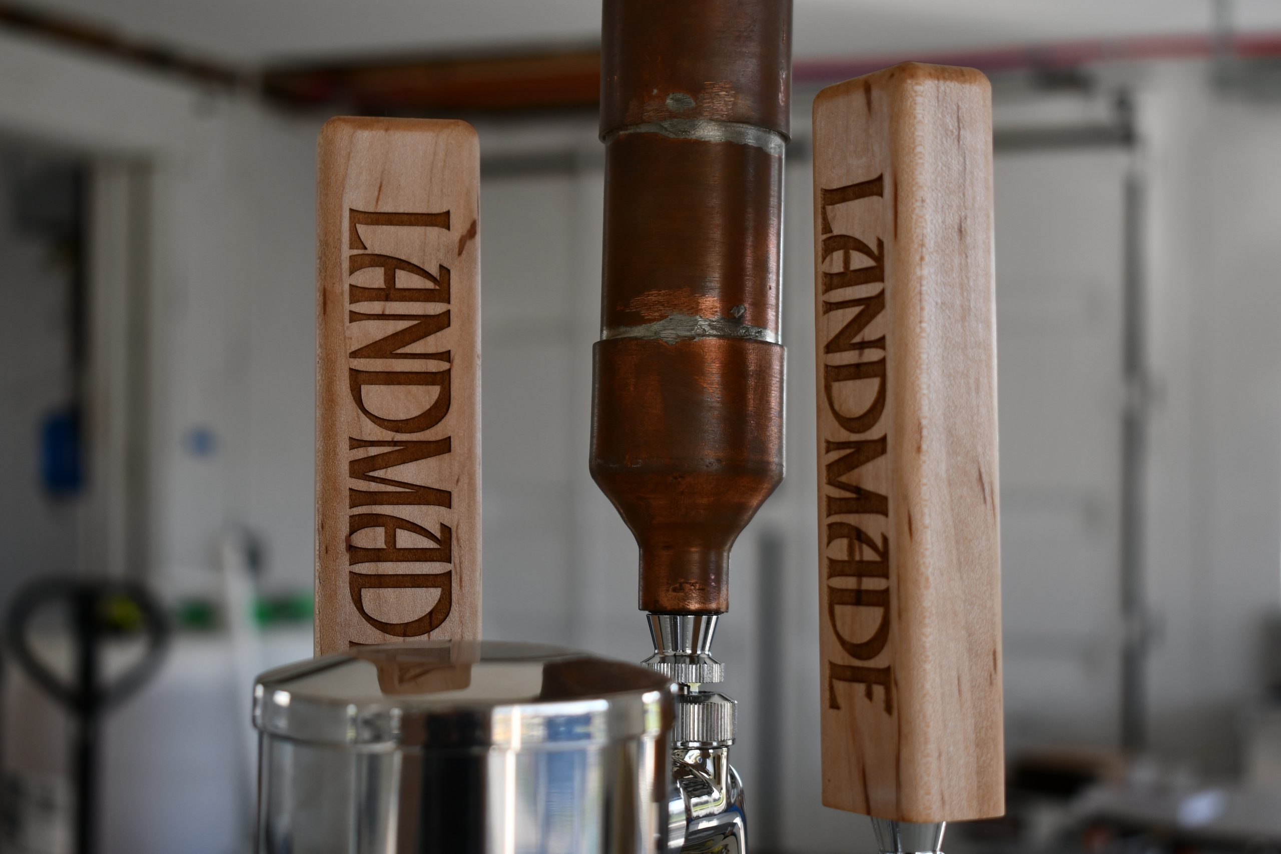 A photo of custom natural wood beer draft handles in a tasting room for Landmade Beer.