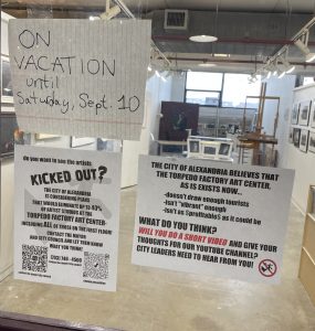 Artists protesting re-jurying process with signs outside studio