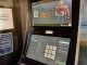 the top half of a sports betting kiosk at 3/4 view with two horizontal screens. the top screen shows a football player and a QR code to scan to "build your bet." the bottom touch screen shows betting details