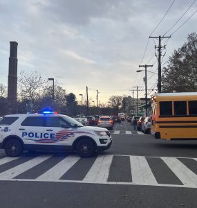 A police car sits behind a school bus