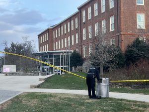 A police officer puts up crime scene tape outside the high school