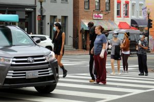 A driver makes a left turn as pedestrians cross the crosswalk.
