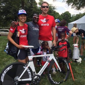 RWB athletes together in front of bicycle