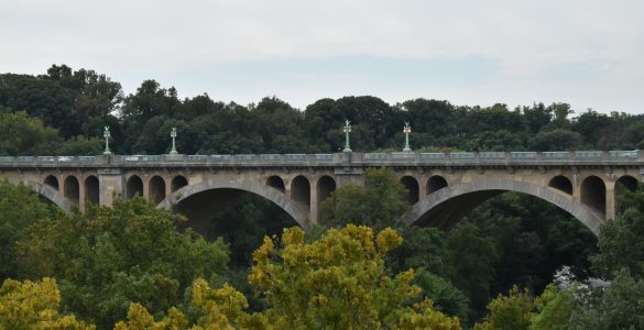 A complete view of the Taft Bridge, surrounded by trees from Rock Creek Park.