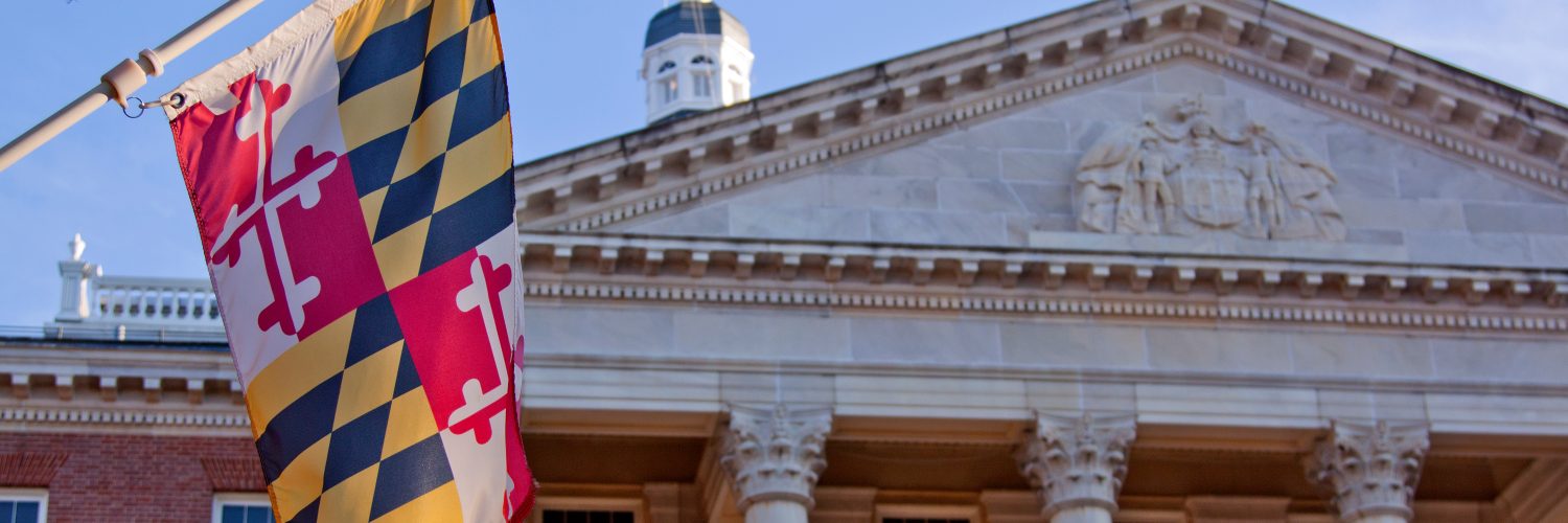 A close up view of the Maryland Statehouse with a state flag in the foreground The Maryland Statehouse with a state flag in the foreground. (Courtesy Glynnis Jones / Adobe Stock)