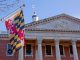 A close up view of the Maryland Statehouse with a state flag in the foreground The Maryland Statehouse with a state flag in the foreground. (Courtesy Glynnis Jones / Adobe Stock)