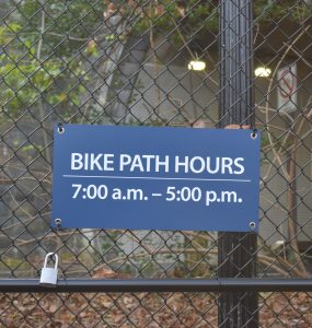 A sign on the Zoo Loop Trail's gate reads "Bike Path hours: 7 a.m. to 5 p.m."