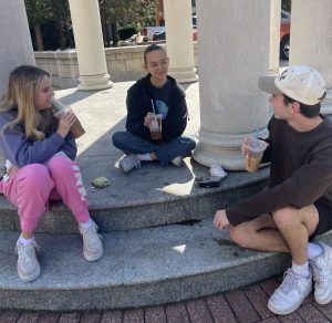 Three students sit chatting.