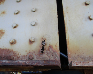 A close-up photo of rusting steel on a bridge.