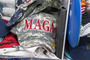 A camouflage hat with "MAGA" written in red letters.