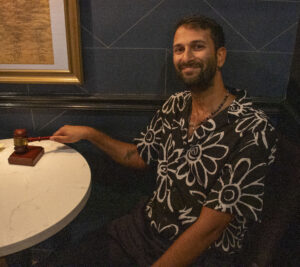 A man holds a gavel at a table at Political Pattie's.