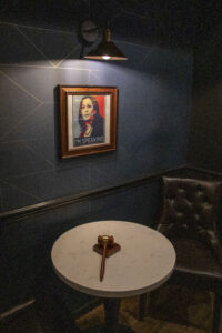 A gavel sits on a table near a portrait of Kamala Harris.