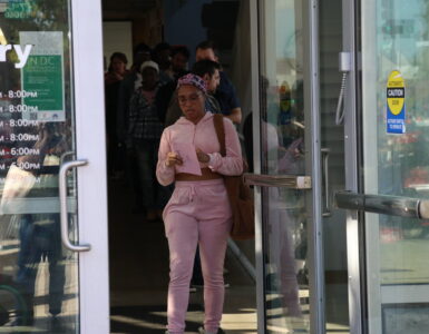 A woman walks toward the door to exit the Shaw Library.