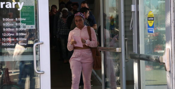 A woman walks toward the door to exit the Shaw Library.