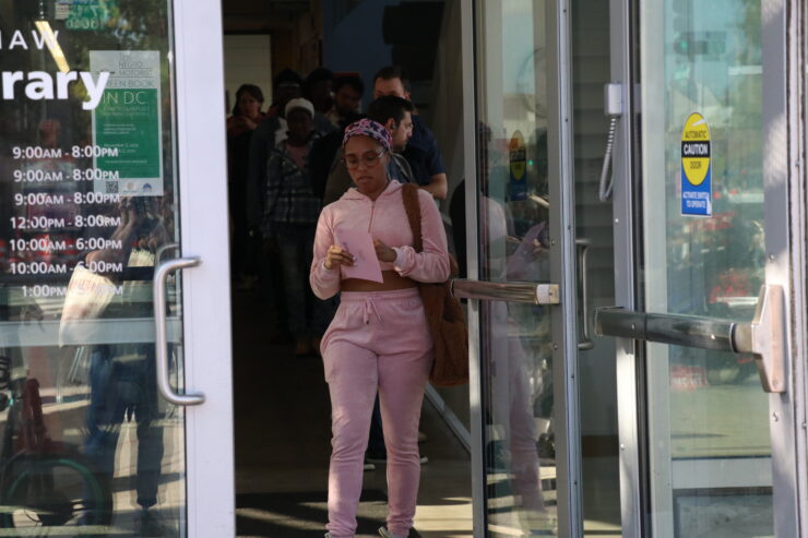 A woman walks toward the door to exit the Shaw Library.