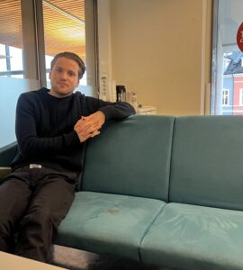 Mikkel Røed Nesse poses on a couch