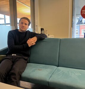 Mikkel Røed Nesse poses on a couch