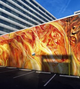 Stunning fiery mural located in NoMa Art District featuring intricate faces and a lion. Photo by Jordan Thornton