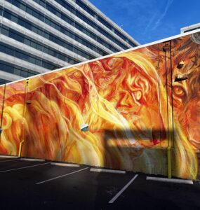 Stunning fiery mural located in NoMa Art District featuring intricate faces and a lion. Photo by Jordan Thornton