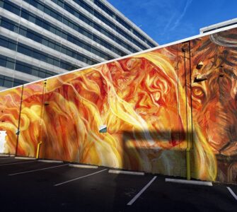 Stunning fiery mural located in NoMa Art District featuring intricate faces and a lion. Photo by Jordan Thornton