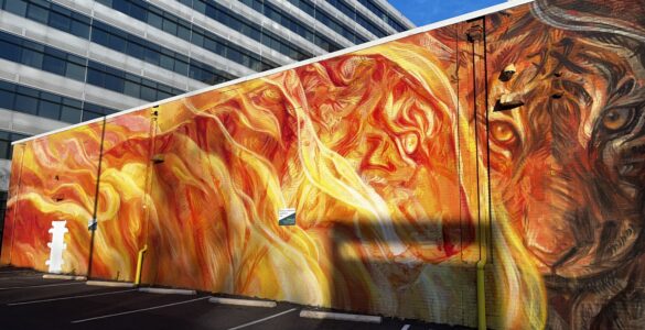 Stunning fiery mural located in NoMa Art District featuring intricate faces and a lion. Photo by Jordan Thornton