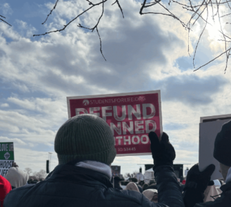 Protestor holding a defund planned parenthood sign at a DC rally