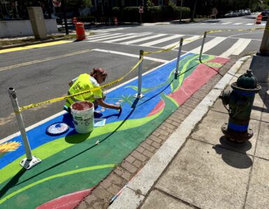 Artist Samantha Hamilton painting a street mural on Capitol Hill as part of Color Your Curb. (Ellen Tannor)