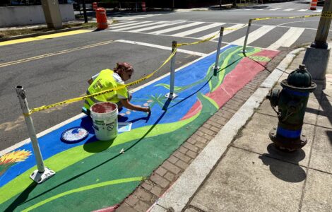 Artist Samantha Hamilton painting a street mural on Capitol Hill as part of Color Your Curb. (Ellen Tannor)