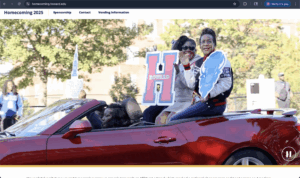 Two women sit on the back of a red convertible with a large red H while waving to a crowd of onlookers