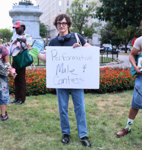 Nick Ransom, winner of the performative male contest, stands victorious while holding the sign for the competition. (Kelly Doyle)