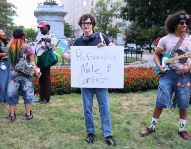Nick Ransom, winner of the performative male contest, stands victorious while holding the sign for the competition. (Kelly Doyle)