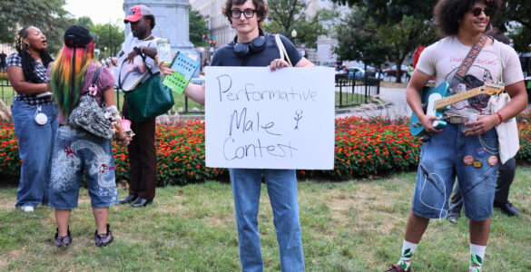 Nick Ransom, winner of the performative male contest, stands victorious while holding the sign for the competition. (Kelly Doyle)
