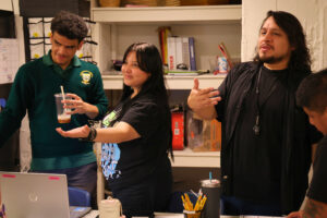 Paso Nuevo Program Director Chris Ríos talks with student participant Balaria Rodríguez and student intern Lorenzo Cruz before the students split into classes. (Kelly Doyle)