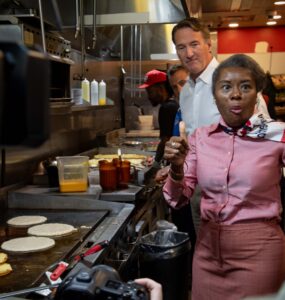 Winsome Earle-Sears, the Republican lieutenant governor of Virginia who is running for the top job, flips pancakes at Shorty's Diner in Richmond with a little help from her boss,Gov. Glenn Youngkin, on Monday. Voters will elect their first female governor on Tuesday. Photo by Ben Ackman