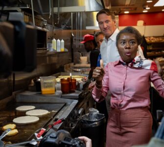 Winsome Earle-Sears, the Republican lieutenant governor of Virginia who is running for the top job, flips pancakes at Shorty's Diner in Richmond with a little help from her boss,Gov. Glenn Youngkin, on Monday. Voters will elect their first female governor on Tuesday. Photo by Ben Ackman