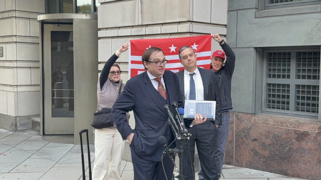 Eric Hamilton, Trump administration attorney, being heckled by Free DC protestors after hearing in U.S. district court. (Ellen Tannor)