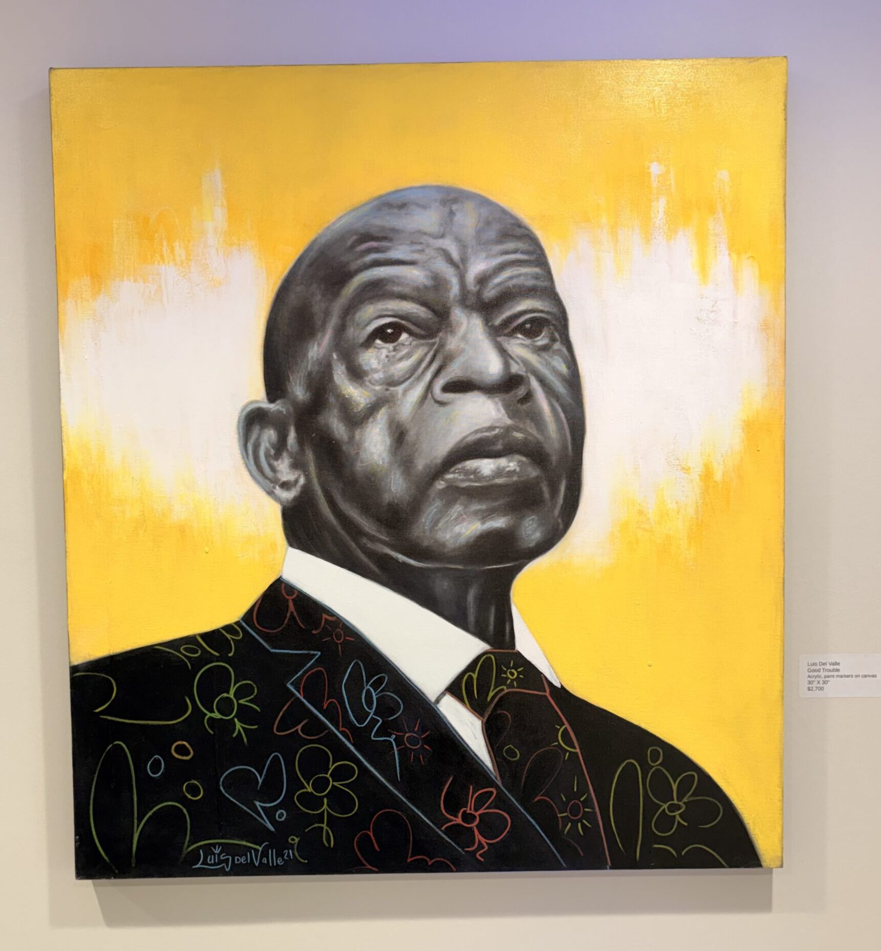 A square canvas depicts a grayscale painting of the late Rep. John Lewis. 