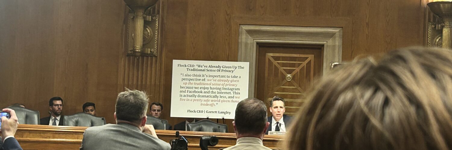 Sen. Josh Hawley sits in front of a white poster board with a statement from Flock CEO Garrett Langley in Dirksen Senate Office Building.