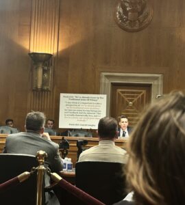 Sen. Josh Hawley sits in front of a white poster board with a statement from Flock CEO Garrett Langley in Dirksen Senate Office Building.