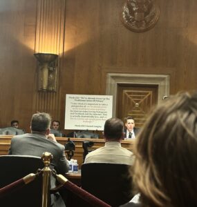 Sen. Josh Hawley sits in front of a white poster board with a statement from Flock CEO Garrett Langley in Dirksen Senate Office Building.