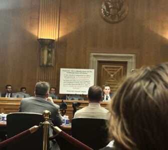 Sen. Josh Hawley sits in front of a white poster board with a statement from Flock CEO Garrett Langley in Dirksen Senate Office Building.