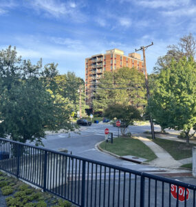 A picture of Edinburgh House, a brown low rise brick building, from across the street on Maple Avenue in Takoma Park.