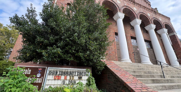 Looking up at the historic Lincoln Temple, an overgrown sign reads "Lincoln Congregational Temple United Church of Christ" and "Shaw Community Center 1701 11 St NW is open."