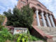 Looking up at the historic Lincoln Temple, an overgrown sign reads "Lincoln Congregational Temple United Church of Christ" and "Shaw Community Center 1701 11 St NW is open."