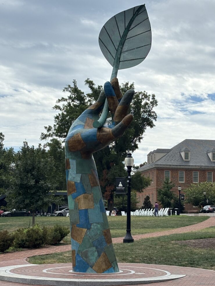 A public sculpture of a giant hand holding a leaf stands in the park at City Ridge in Cathedral Heights. (Photo by Albina Yeromina)