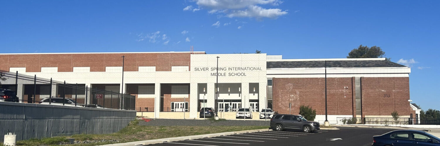 A photo of the entrance of Silver Spring International Middle School as seen from the sidewalk in front of the school.