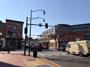 Under a clear, blue sky, cars and trucks pass each other at the intersection of Martin Luther King Jr. SE Ave and Marion Barry Aven SE.