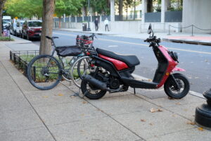 A moped and bicycle parked on the sidewalk in NoMa. 
